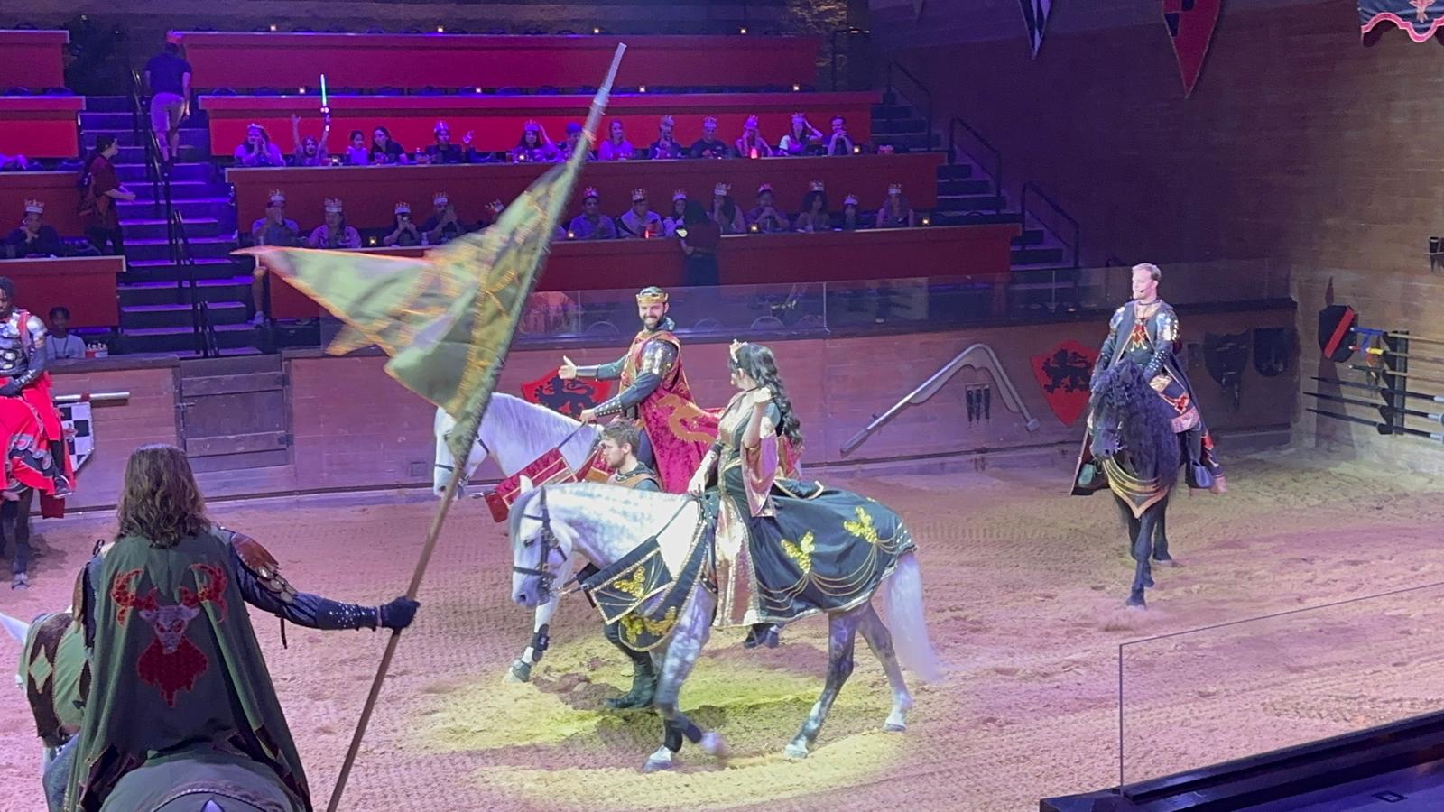 Travis Jones performing at Medieval Times arena with knights on horseback